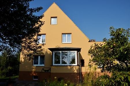 Helle Gelbe Fassade eines Einfamilienhauses mit Anbau