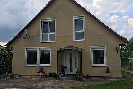 Braun verputztes Wohnhaus vor Sanierungsarbeiten an der Fassade 