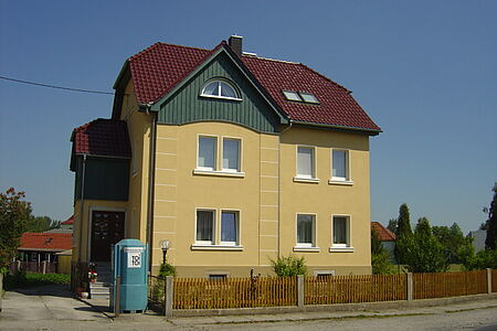 Villa mit orange-gelb verputzter Fassade