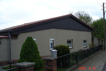 Bungalow mit Satteldach und veralteter Fassade in Grau