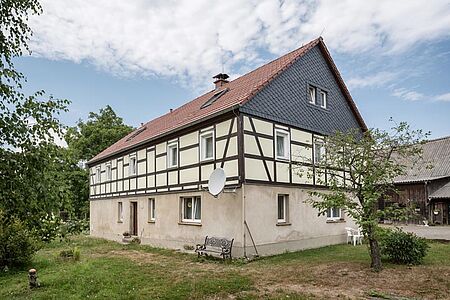 Fachwerkhaus mit pastellgelben Fassadenelementen zwischen den Holzbalken