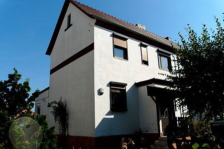 Reihenhaus mit veralteter Fassade in verschmutztem Weiß