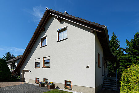 Hellblaues Wohnhaus mit frischen Spezialputzfassaden und asymmetrischer Bauweise