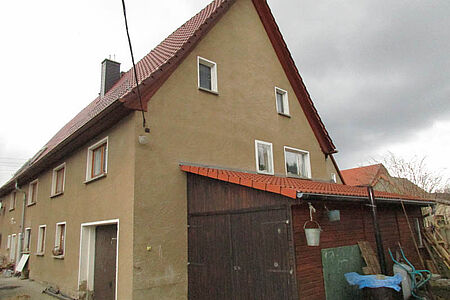 Braun verputztes Zweifamilienhaus vor der Fassadensanierung