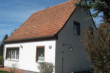 Einfamilienhaus mit spitzem Satteldach und weißer Fassade
