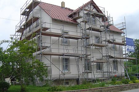 Dreistöckiges Mehrfamilienhaus mit Gerüst während der Fassadensanierung