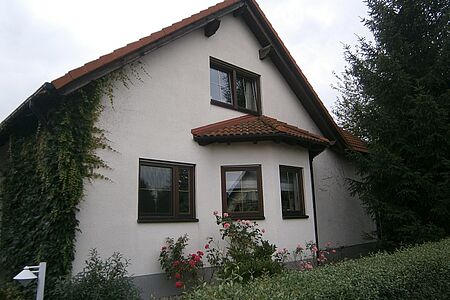 Sehr helles pastelloranges Einfamilienhaus mit bewachsener Fassade