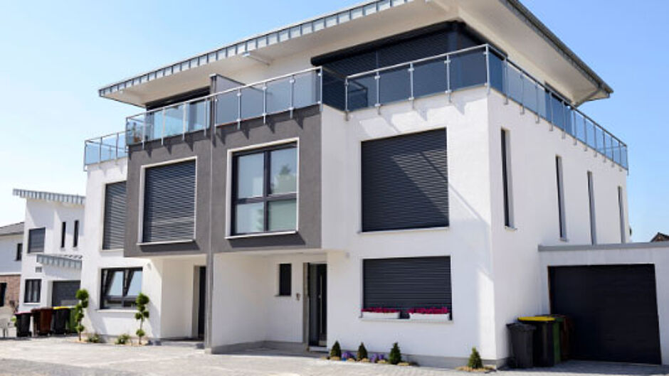 Modernes Zweifamilienhaus mit Balkonen und großen Fenstern