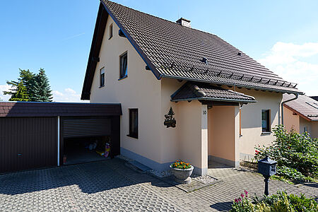 Kleines Einfamilienhaus mit Doppelgarage und sehr heller Fassade in Pastellorange