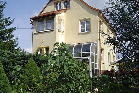Villa im Grünen mit Wintergarten und Flecken auf der Fassade