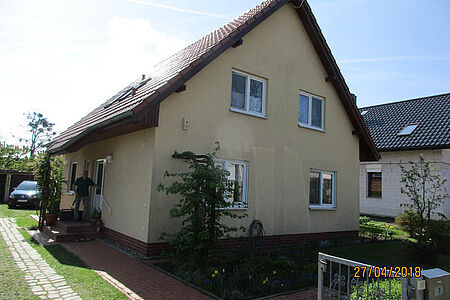 Gelbes Einfamilienhaus mit fleckiger Fassade