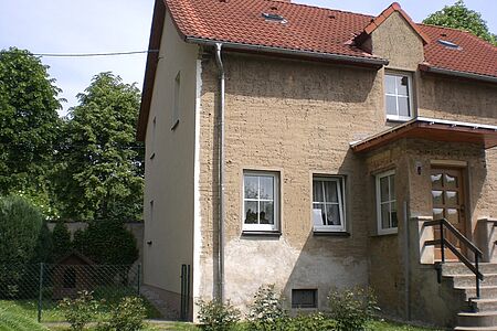 Dreistöckiges Haus mit veralteter Fassade in verschiedenen Farben
