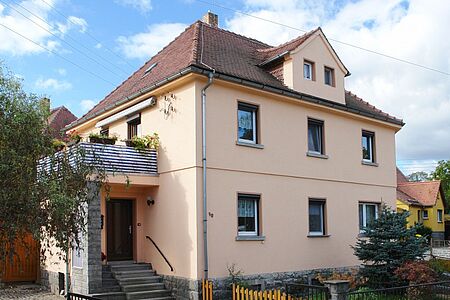 Dreistöckiges Haus mit pastelloranger Spezialfassade