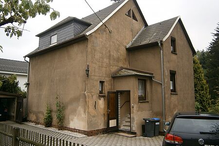 Großes braunes Haus mit starken witterungsbedingten Schäden 
