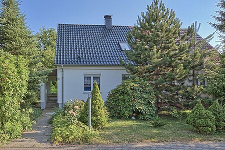 Kleines Haus mit weißer Fassade im Grünen