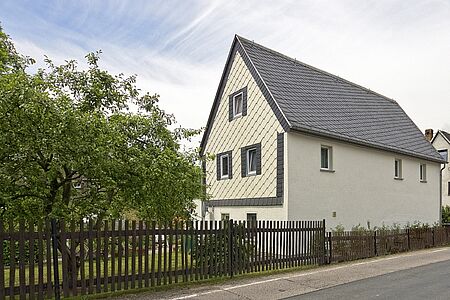 Einfamilienhaus mit drei Stockwerken und ebenmäßig weißer Fassade