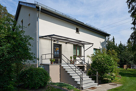 Weiß gestrichenes Wohnhaus mit saniertem Treppenaufgang