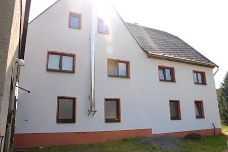 Sonne fällt über Dachgiebel eines Einfamilienhauses mit neuer weißer Fassade