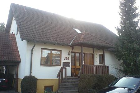 Einfamilienhaus mit Garage und Treppenaufgang vor energetischer Sanierung