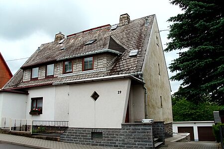 Einfamilienhaus mit verwitterter Fassade und Grünspan