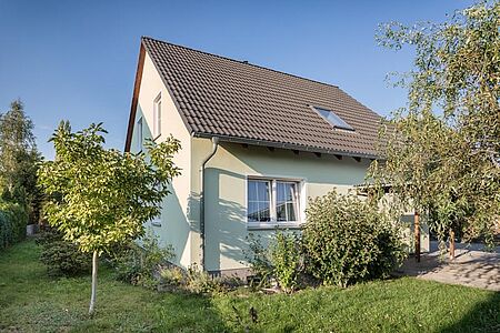Einfamilienhaus mit hellgrüner und weißer Fassade