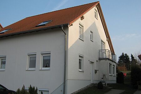 Weißes Doppelhaus vor Sanierungsmaßnahmen