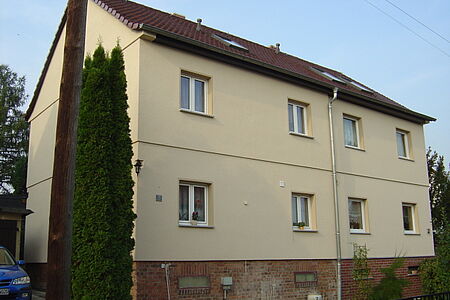 Eierschalenfarbenes Reihenhaus mit sanierte Fassade