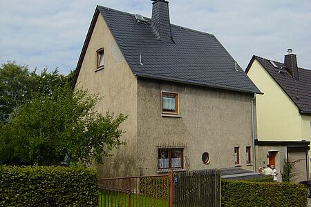 Dreistöckiges Haus mit brauner, fleckiger Fassade