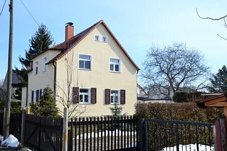 Großes, hellgelber Wohnhaus nach der Fassadensanierung
