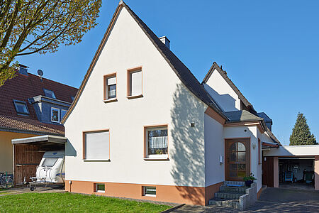 Strahlend weißes Einfamilienhaus mit spitzem Satteldach
