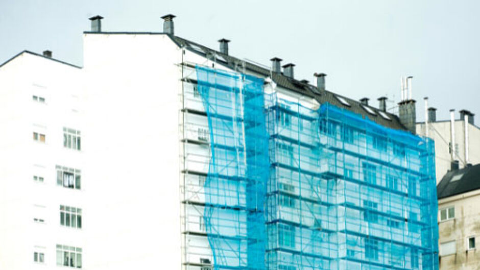 Weißes Hochhaus mit Baugerüst