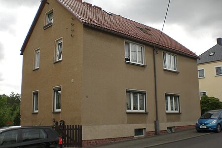 Doppelhaus mit drei Stockwerken und fleckig-brauner Fassade