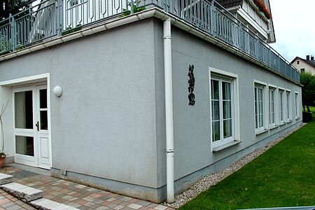 Hellblaues Haus mit verschmutzter Fassade im Erdgeschoss