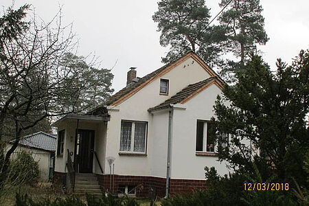 Wohnhaus mit sanierungsbedürftiger Fassade in schmutzigem Weiß