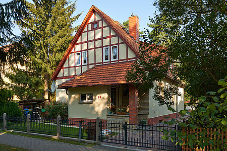 Hellgelber Fachwerkhaus mit rotbraunen Holzelementen 