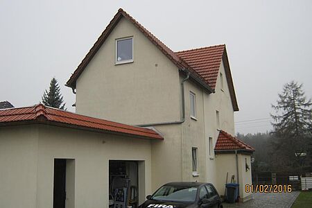 Pastellgelbes Wohnhaus mit verschmutzter Fassade