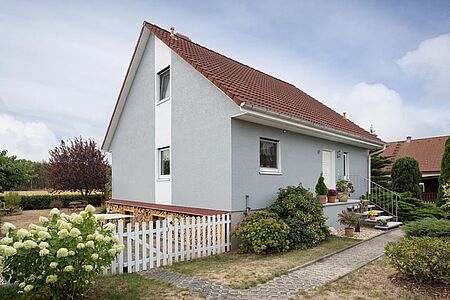 Hellblaues Einfamilienhaus mit einem weißen Streifen auf einer Seite