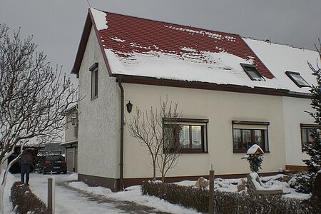 Doppelhaus mit einer Fassade in verschmutztem Weiß