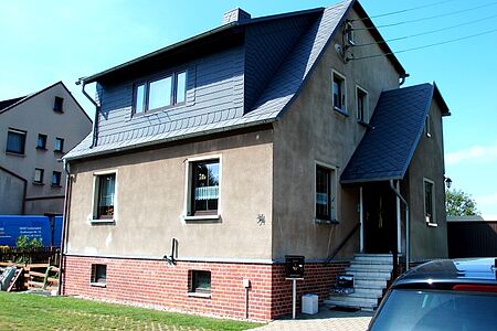 Einfamilienhaus mit verblichenen und dunklen Stellen an der Fassade