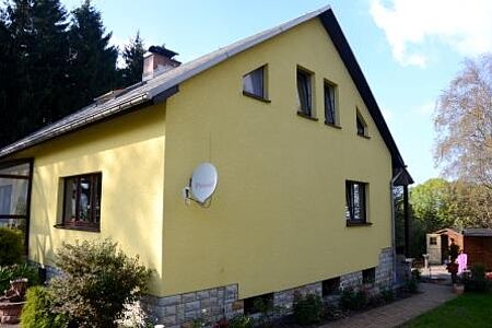 Wohnhaus mit sanierter Fassade in sonnigem Gelb