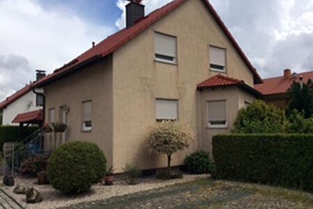 Hellbraunes Einfamilienhaus mit verwitterter Fassade