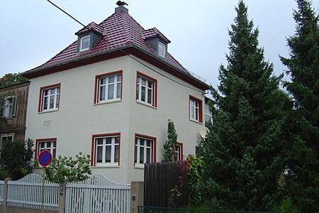 Dreistöckige Villa mit Zeltdach und heller Fassade