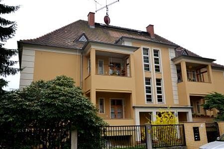 Mehrfamilienhaus mit Balkonen und oranger Spezialputzfassade