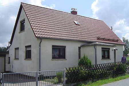 Einfamilienhaus mit veralteter Fassade in schmutzigem Weiß