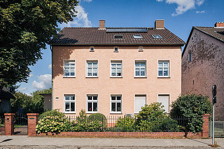 Korallenfarbenes Reihenhaus mit ebenmäßiger Fassade