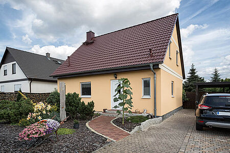 Einfamilienhaus mit ebenmäßiger Fassade in hellem Orange 