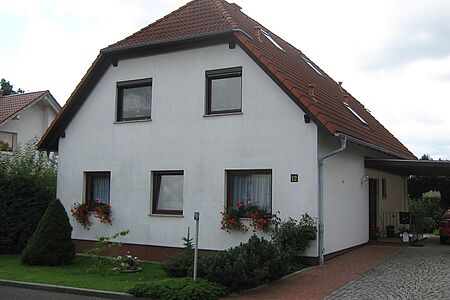 Großes Einfamilienhaus mit weißer, verwitterter Fassade