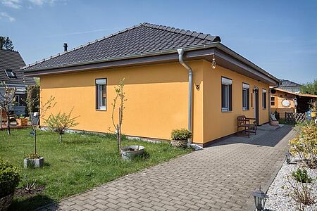 Oranges Bungalow mit schwarzem Walmdach