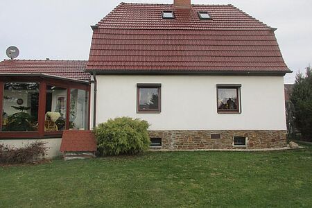 Weißes Einfamilienhaus mit Wintergarten