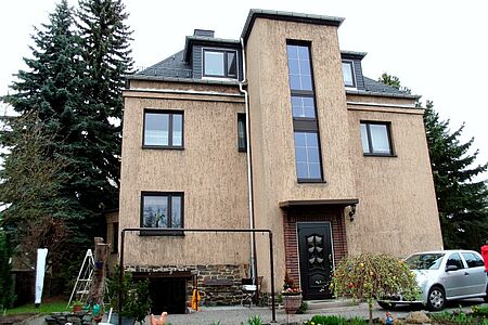 Einfamilienhaus mit Witterungsspuren an der Hauswand